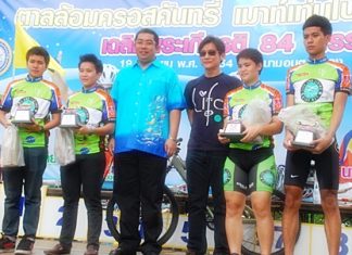 Former Minister for Sports and Tourism, Sonthaya Khunplome, center, presents trophies to one of the winning teams.